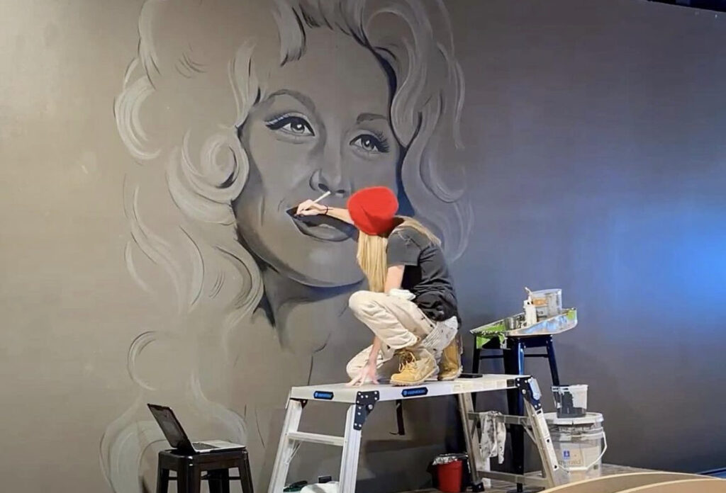 Artist Maisie Thompson paints Dolly Parton at The Pines Downtown in Sevierville, TN.