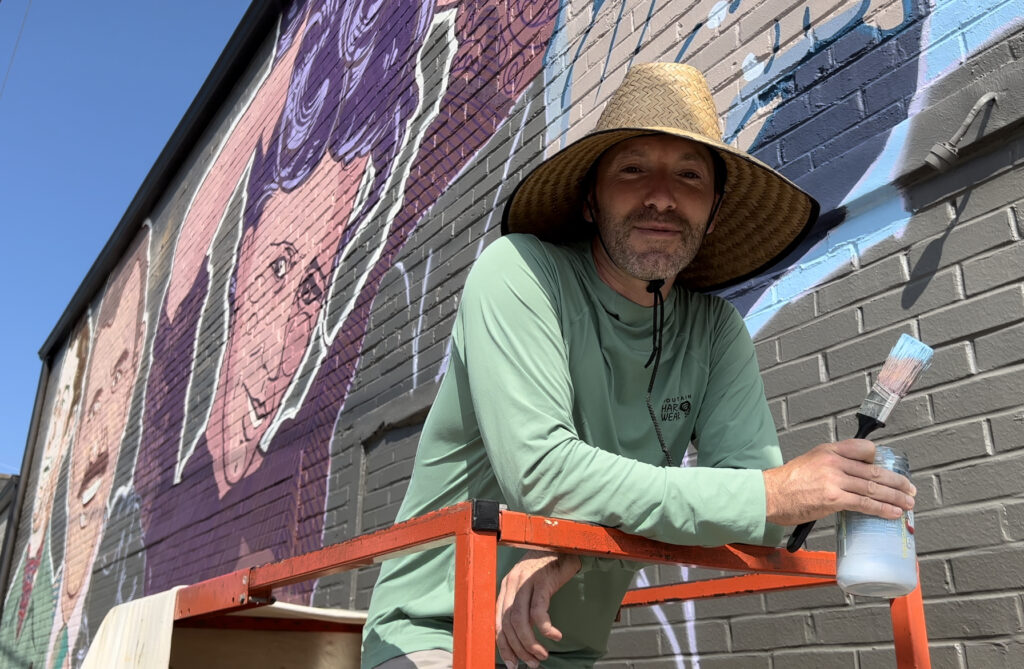 Seth Bishop, painter of mural in Downtown Sevierville, working on his project at The Pines Downtown.